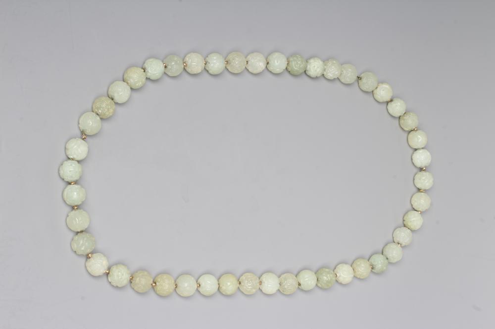 A STRING OF CHINESE CELADON JADE BEADS, the forty six spherical beads carved with scroll and Image