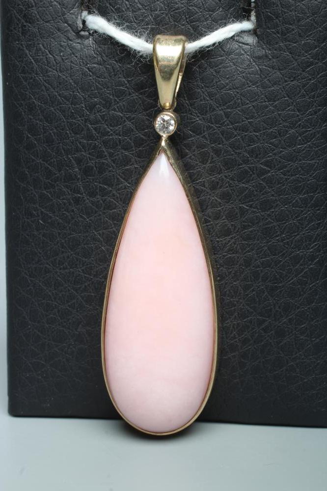 A PINK CHALCEDONY PENDANT, the shaped polished stone collet set in 9ct gold with a diamond point Image
