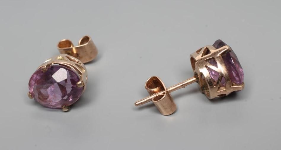 A PAIR OF AMETHYST EAR STUDS, the oval facet cut stones claw set to a plain unmarked frame (Est. Image