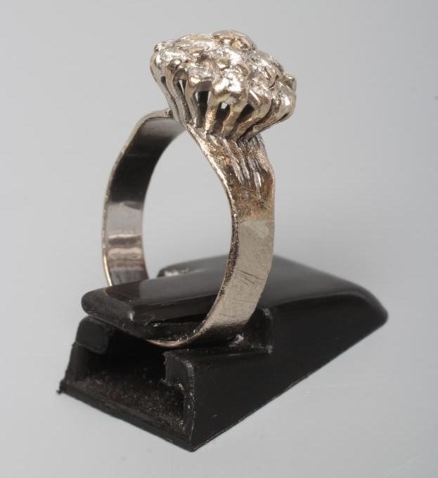 A DIAMOND CLUSTER RING, the mix cut stones claw set to a later white unmarked shank, size L (Est. Image