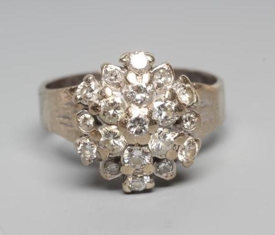 A DIAMOND CLUSTER RING, the mix cut stones claw set to a later white unmarked shank, size L (Est. Image