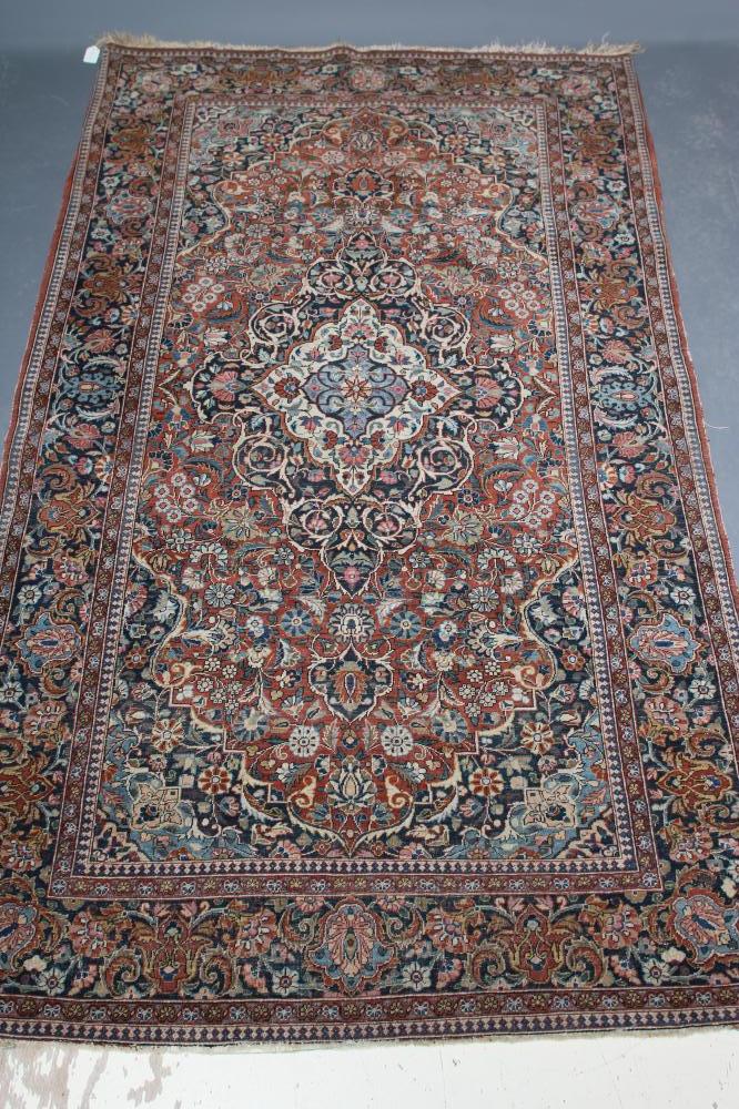 A PERSIAN RUG, the red floral field with navy blue and ivory gul, the navy blue main border with Image