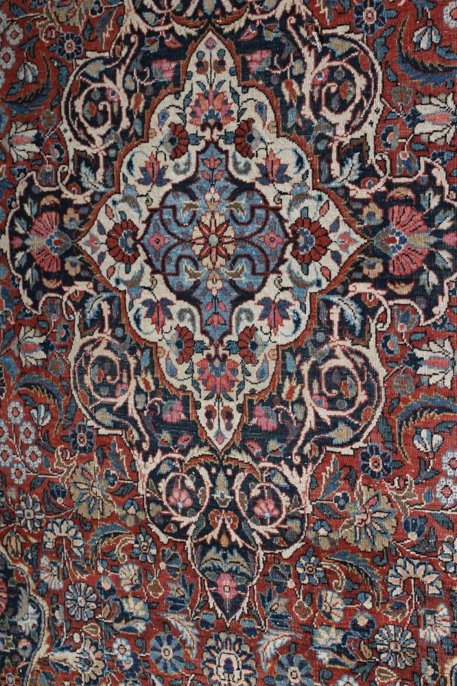 A PERSIAN RUG, the red floral field with navy blue and ivory gul, the navy blue main border with Image