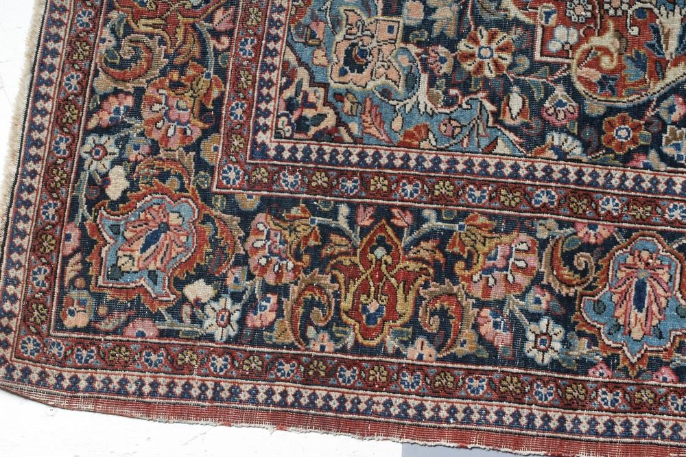 A PERSIAN RUG, the red floral field with navy blue and ivory gul, the navy blue main border with Image