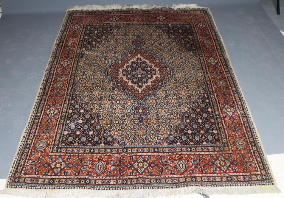 A PERSIAN RUG, the ivory floral field with central gul in red, ivory and navy blue, conforming Image