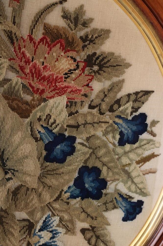 A MID VICTORIAN OVAL WOOLWORK PICTURE worked in coloured wools in full cross stitch with flowers Image