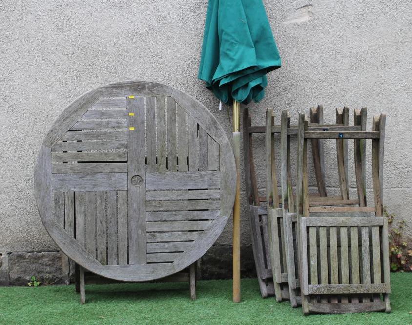 A TEAK TABLE AND CHAIRS, manufactured by Neptune, the folding circular slatted table 42 1/2" wide, Image