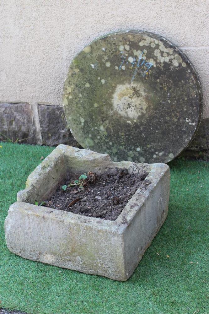 A SANDSTONE MILL WHEEL, 23 1/2" high, together with a square sandstone trough, 18" x 18" x 9" (2) Image