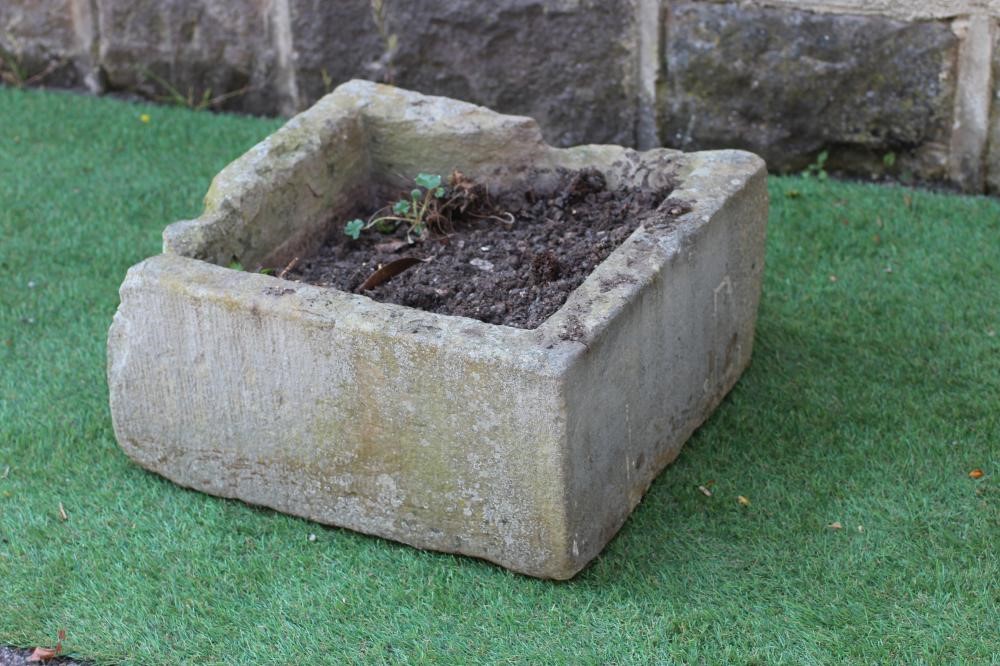 A SANDSTONE MILL WHEEL, 23 1/2" high, together with a square sandstone trough, 18" x 18" x 9" (2) Image