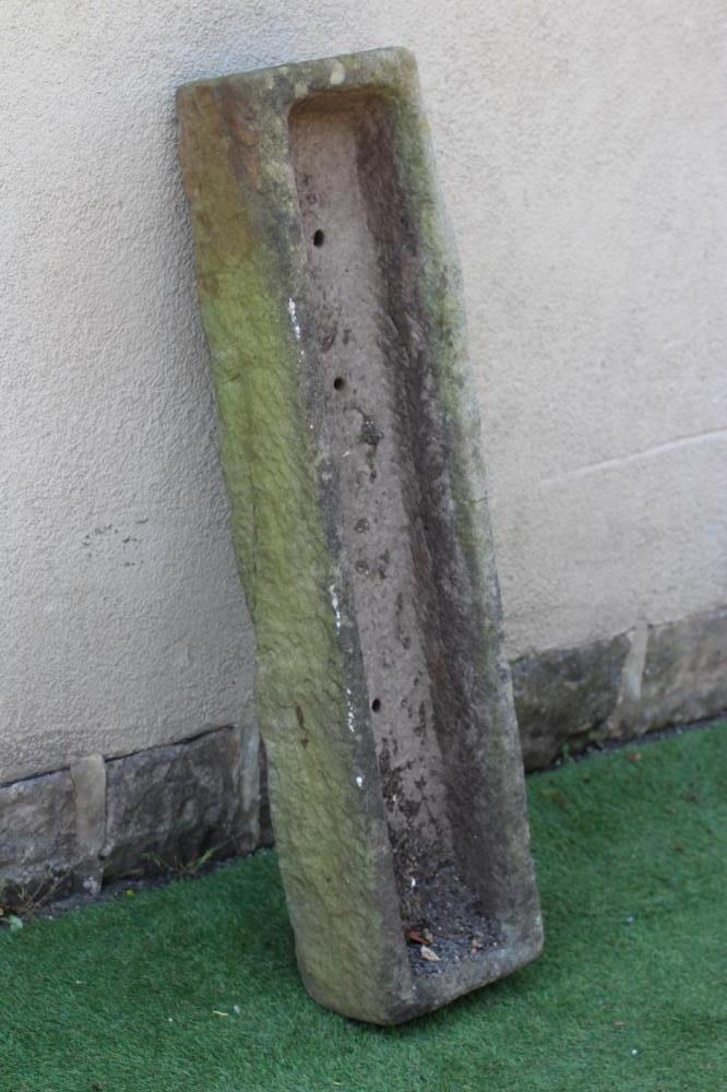 A SANDSTONE TROUGH of rough hewn narrow oblong form, 47 1/2" x 12" x 7 1/2" (Est. plus 24% premium Image