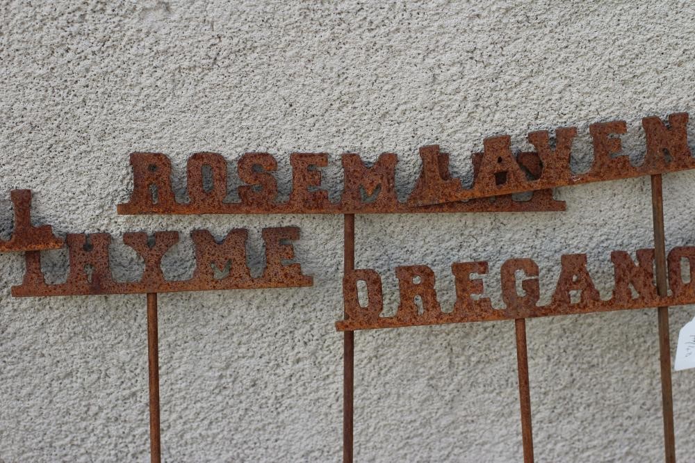 A SET OF TEN RECLAIMED METAL HERB LABELS, each on a turned post with rust patination, 6" - 13" x 37 Image