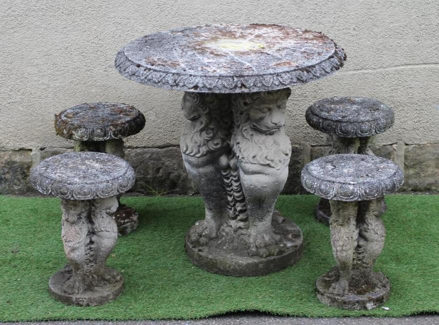 A CAST STONE TABLE, the circular top with ovolu rim on lion monopodiae supports and circular base, Image