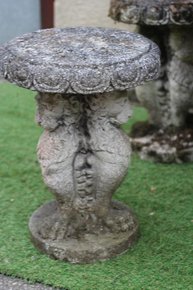 A CAST STONE TABLE, the circular top with ovolu rim on lion monopodiae supports and circular base, Image