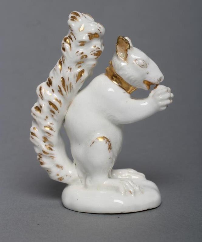 A DERBY PORCELAIN SQUIRREL, c.1800, modelled holding a nut to its mouth, with gilded highlights, Image