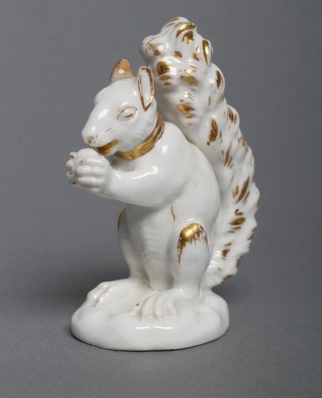 A DERBY PORCELAIN SQUIRREL, c.1800, modelled holding a nut to its mouth, with gilded highlights, Image