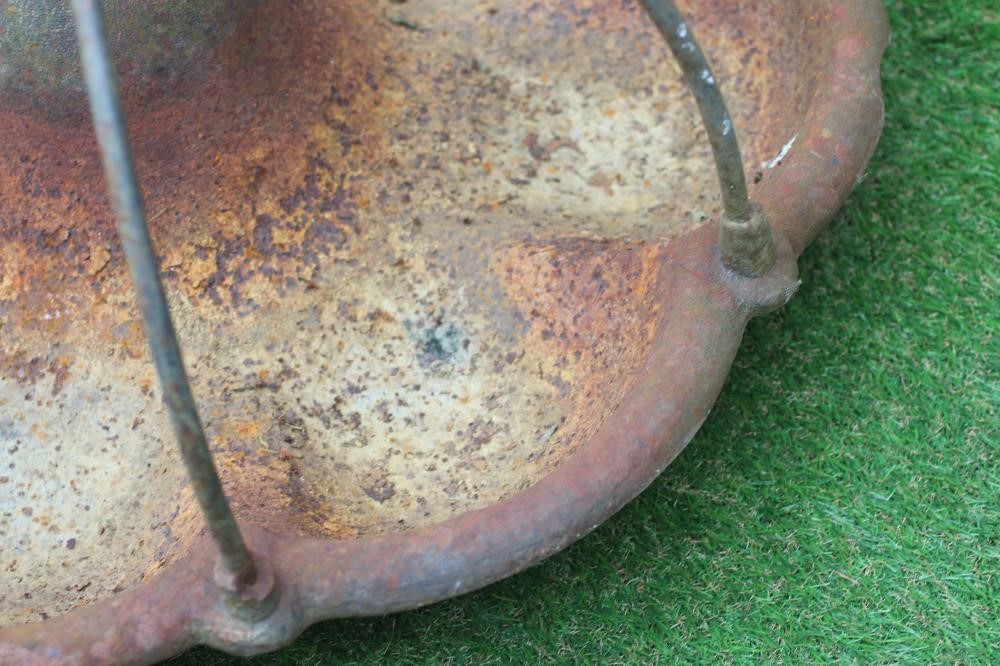 A CAST IRON PIG TROUGH, 20th century, of circular form with raised circular food aperture, 30" wide Image