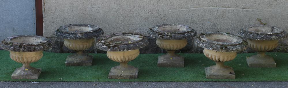 A SET OF SIX CAST STONE URNS of low half fluted campana form with ovolu moulded rims, on waisted Image