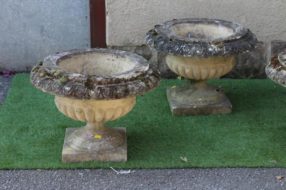 A SET OF SIX CAST STONE URNS of low half fluted campana form with ovolu moulded rims, on waisted Image