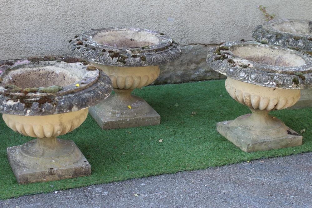 A SET OF SIX CAST STONE URNS of low half fluted campana form with ovolu moulded rims, on waisted Image