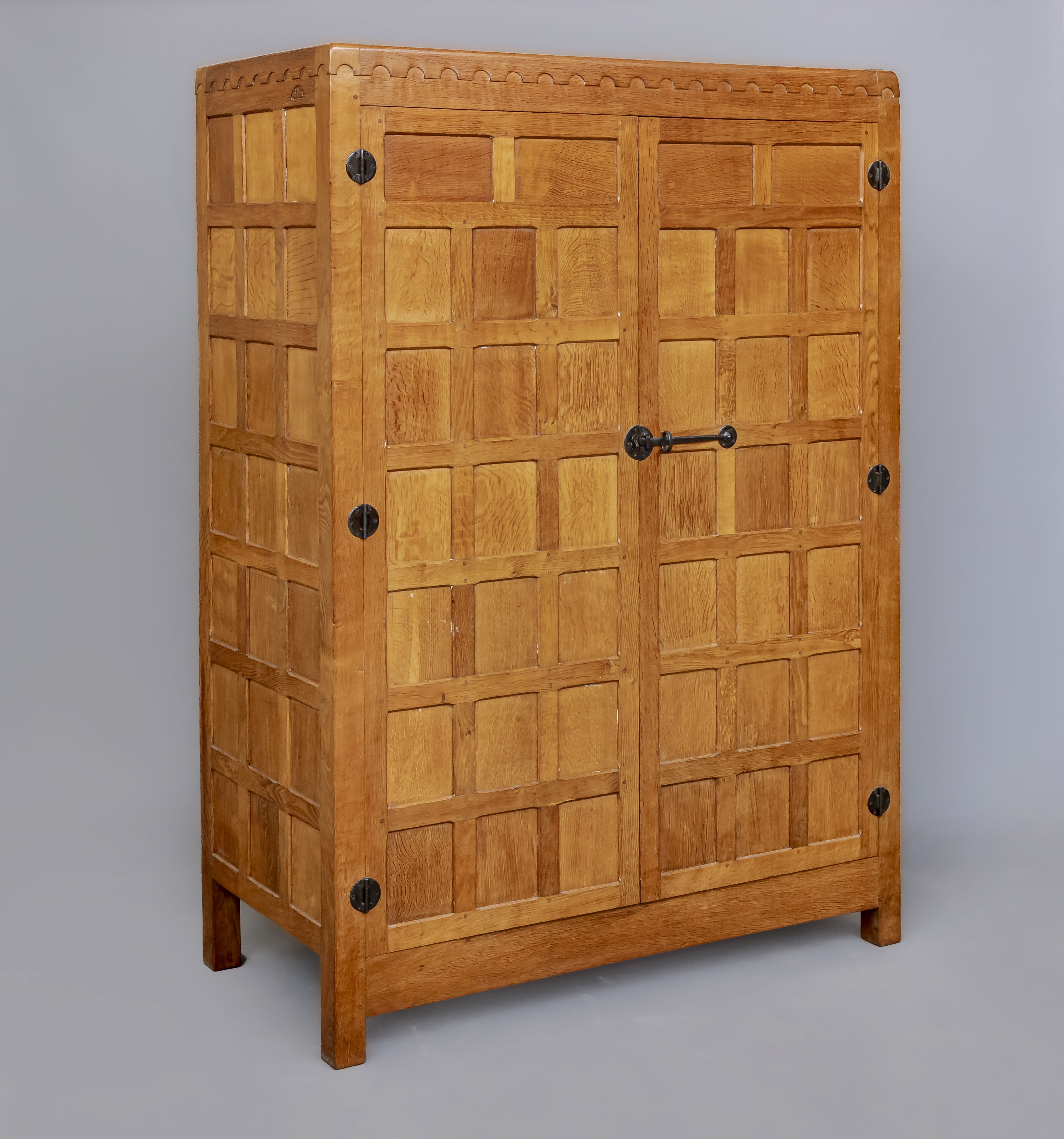 A ROBERT THOMPSON ADZED OAK DOUBLE WARDROBE of multi-panelled form with half penny moulded cornice Image