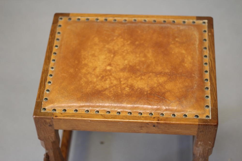 A ROBERT THOMPSON ADZED OAK STOOL of oblong form with padded cow hide seat Image