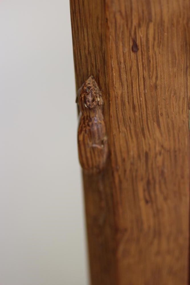 A ROBERT THOMPSON ADZED OAK BEDSIDE CABINET of canted multi-panelled oblong form Image