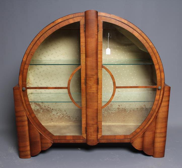 AN ART DECO WALNUT DISPLAY CABINET of circular form with two astragal glazed doors with turned brass Image