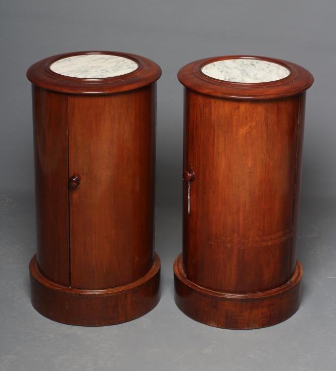A PAIR OF VICTORIAN MAHOGANY BEDSIDE CABINETS of cylindrical form with inset veined white marble top Image