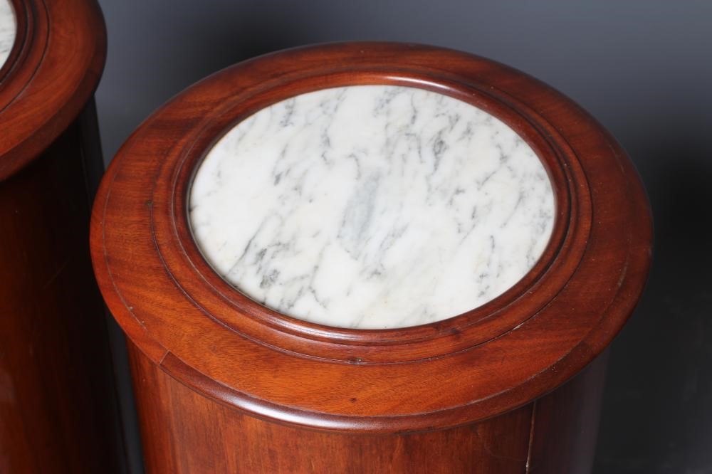A PAIR OF VICTORIAN MAHOGANY BEDSIDE CABINETS of cylindrical form with inset veined white marble top Image