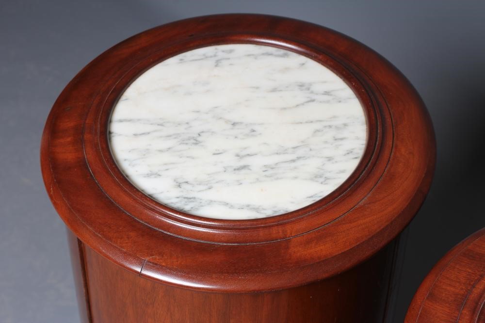 A PAIR OF VICTORIAN MAHOGANY BEDSIDE CABINETS of cylindrical form with inset veined white marble top Image