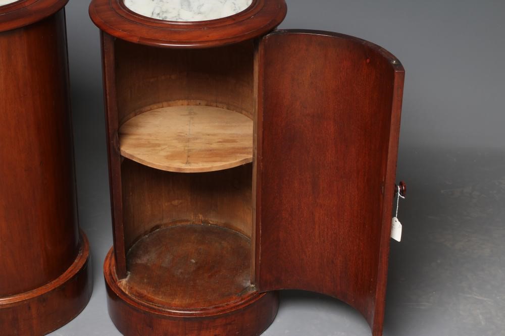 A PAIR OF VICTORIAN MAHOGANY BEDSIDE CABINETS of cylindrical form with inset veined white marble top Image