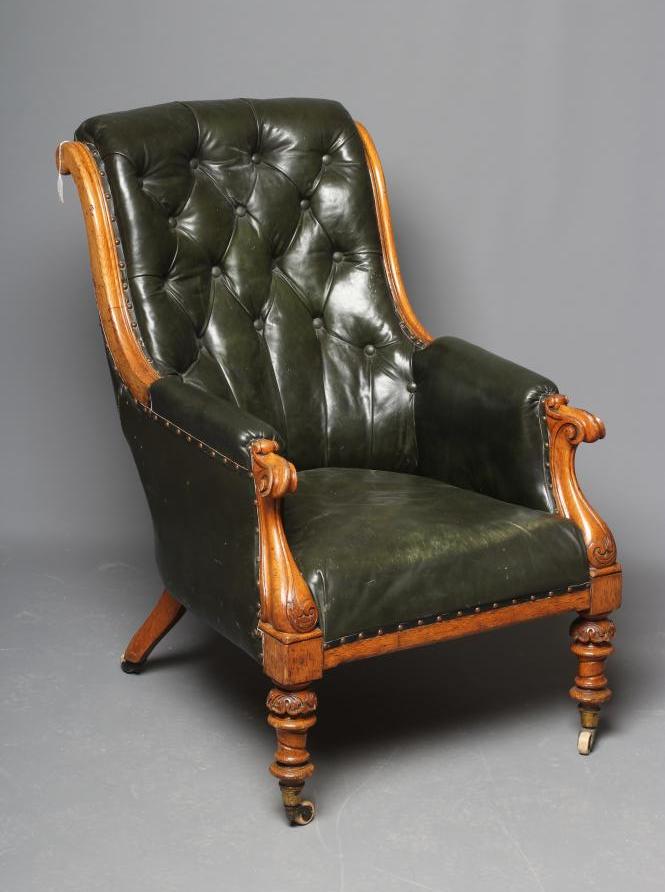 AN MID VICTORIAN OAK FRAMED ARMCHAIR button upholstered in green leather Image