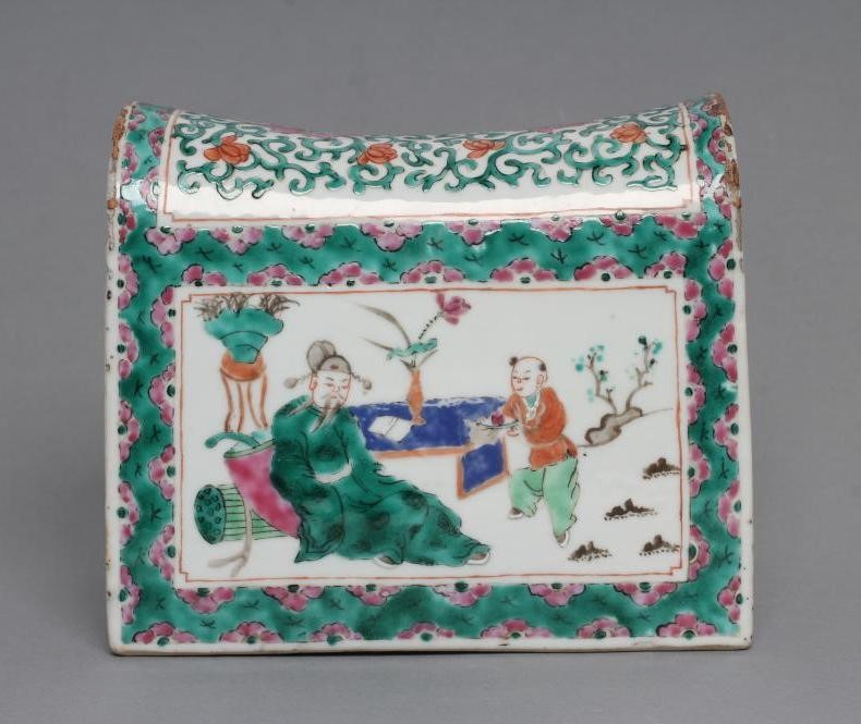 A CANTONESE PORCELAIN FAMILLE ROSE PILLOW of domed oblong form with one quatrefoil pierced end Image
