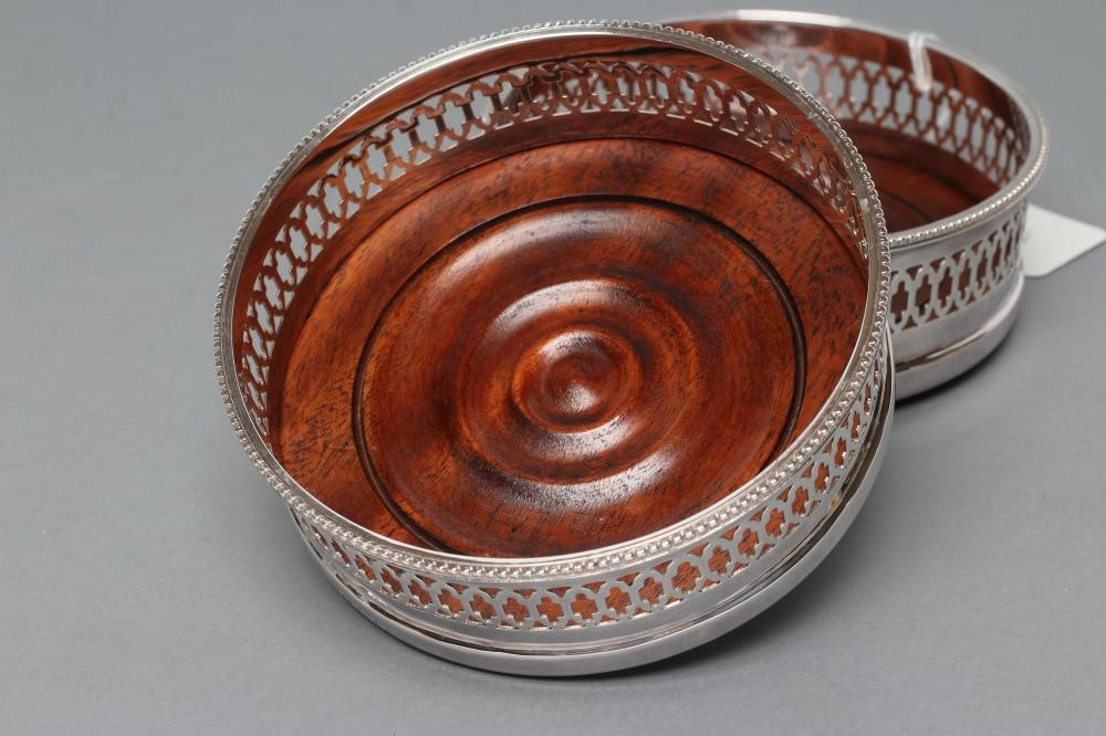 A PAIR OF SILVER BOTTLE COASTERS Image