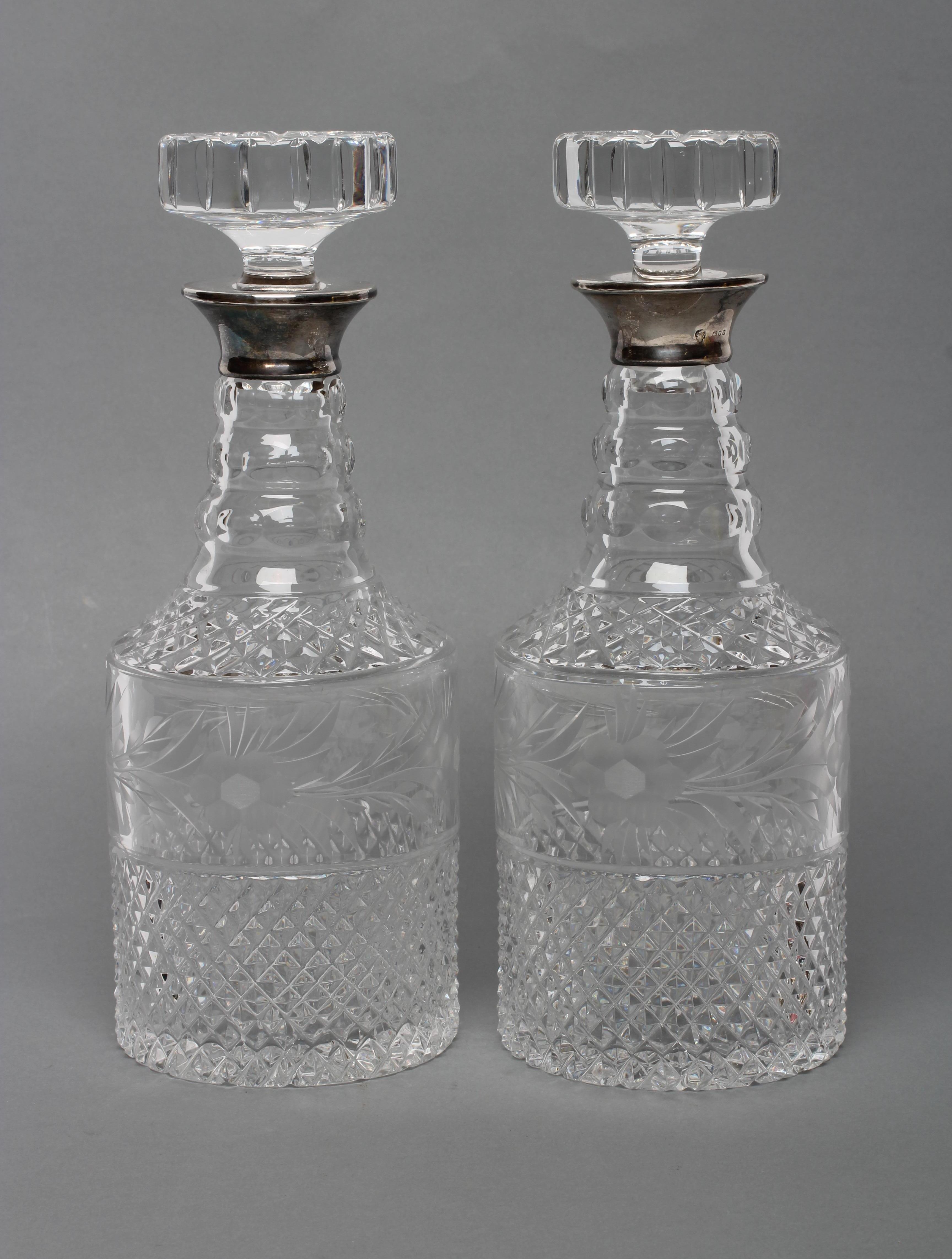 A PAIR OF SILVER MOUNTED TRIPLE RING NECK GLASS MALLET DECANTERS AND STOPPERS with diamond moulded Image