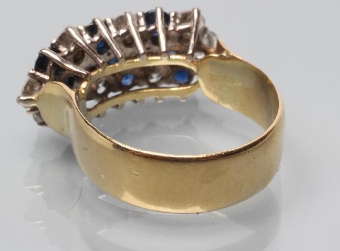 A DIAMOND AND SAPPHIRE HALF HOOP RING Image