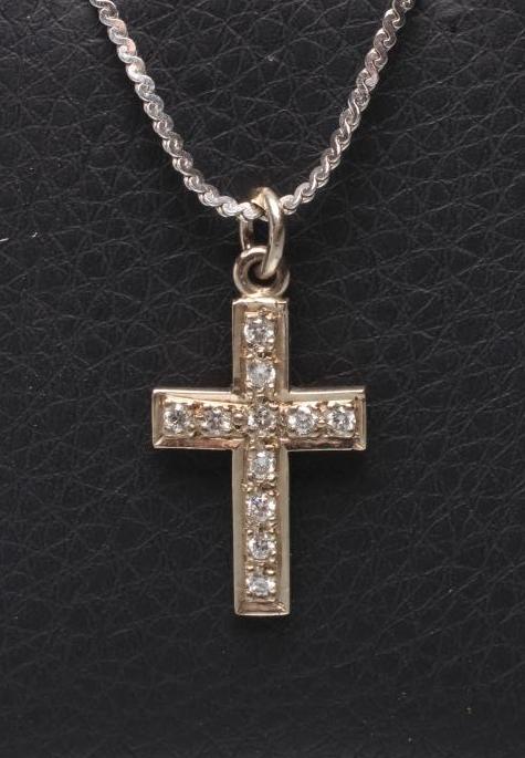 A DIAMOND CROSS PENDANT point set with eleven small round brilliants to a plain unmarked frame Image