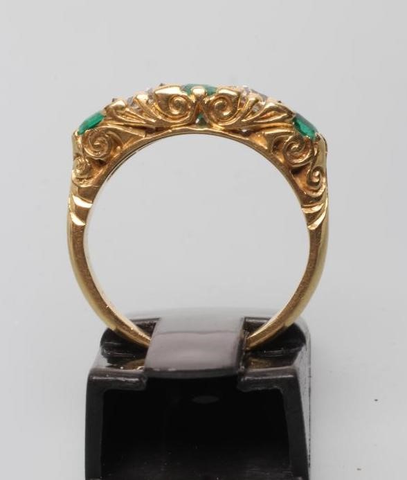 A FIVE STONE EMERALD AND DIAMOND HALF HOOP RING Image