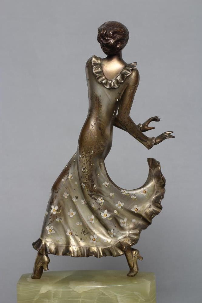 AFTER LORENZL - an Art Deco spelter figure modelled as a young fashionable lady wearing a daisy Image