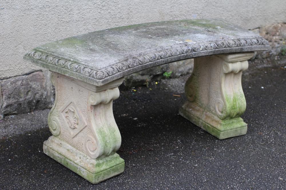 A COMPOSITION GARDEN BENCH of crescent form with ovolu moulded edge Image