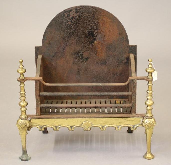 A BAROQUE STYLE CAST IRON AND BRASS FIRE BASKET Image