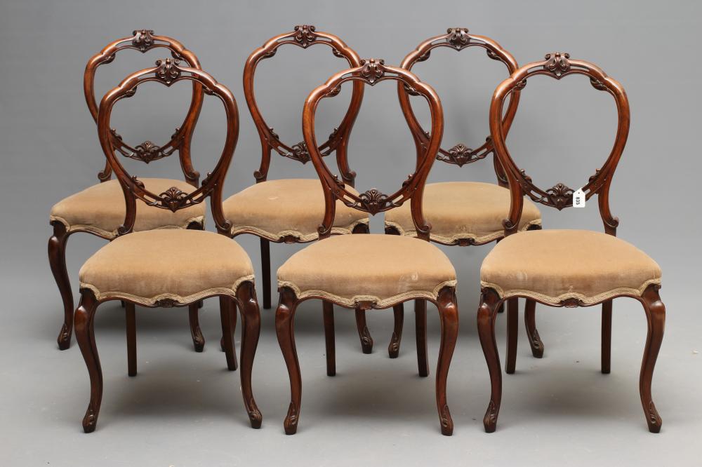 A SET OF SIX VICTORIAN WALNUT DINING CHAIRS of open balloon back form carved with foliate scrolls Image