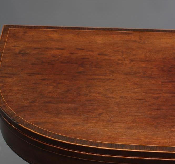 A REGENCY "PLUM PUDDING" MAHOGANY FOLDING CARD TABLE of rounded oblong form Image