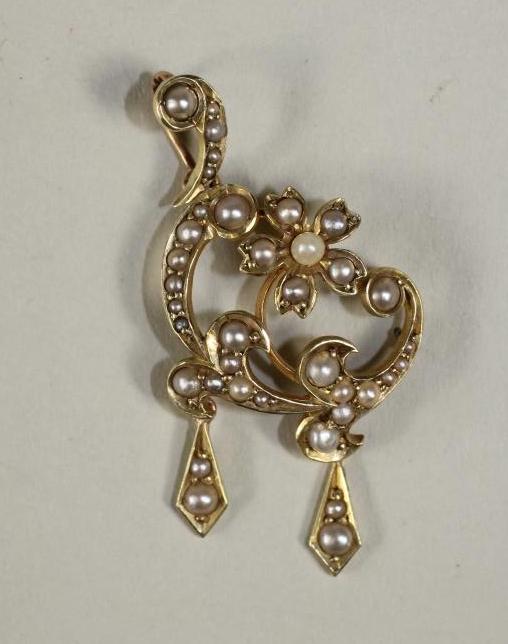 AN EDWARDIAN 15CT GOLD AND SEED PEARL PENDANT of asymetrical open scroll form with two drops Image