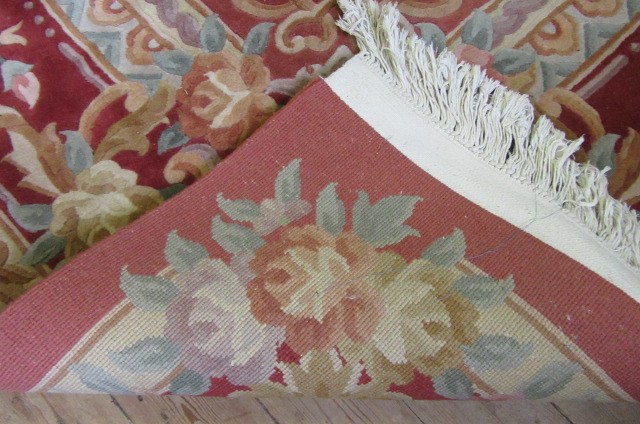 A CHINESE WASHED AND FRINGED AUBUSSON DESIGN CARPET with cream floral medallion and borders on a Image
