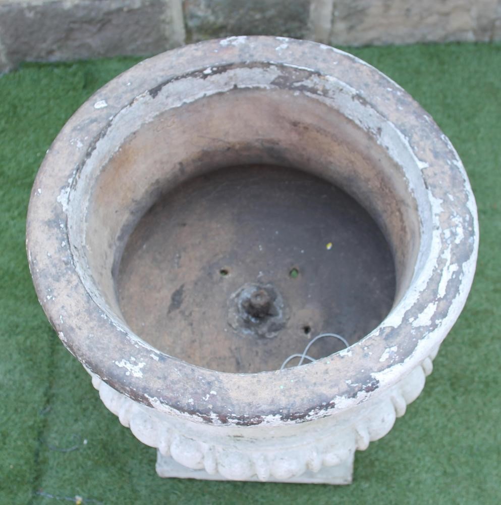 A VICTORIAN TERRACOTTA URN of circular half fluted form with broad flat moulded rim Image