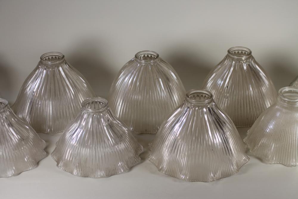 A SET OF FOUR HALOFLAME CLEAR GLASS LAMP SHADES of ribbed bell form with waved rim Image