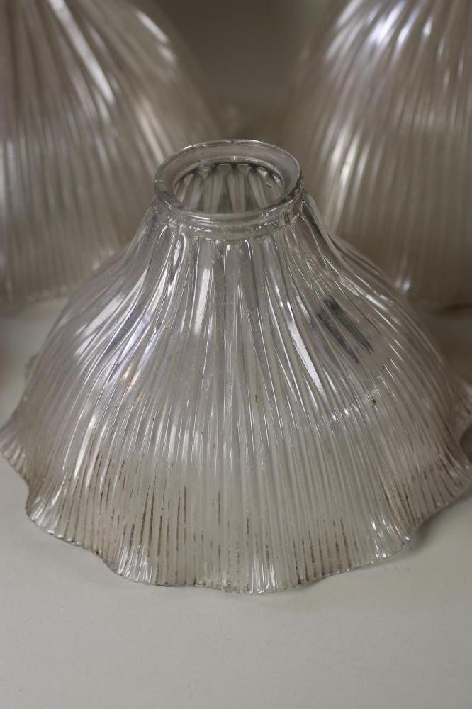 A SET OF FOUR HALOFLAME CLEAR GLASS LAMP SHADES of ribbed bell form with waved rim Image