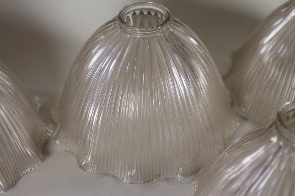 A SET OF FOUR HALOFLAME CLEAR GLASS LAMP SHADES of ribbed bell form with waved rim Image