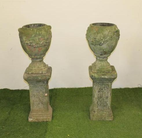 A PAIR OF TERRACOTTA URNS of ovoid form with floral festoons in relief Image